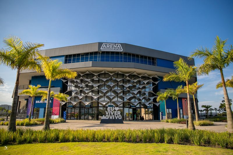 Fachada da Arena Opus em Santa Catarina, arena multiuso com estrutura moderna e palmeiras na entrada